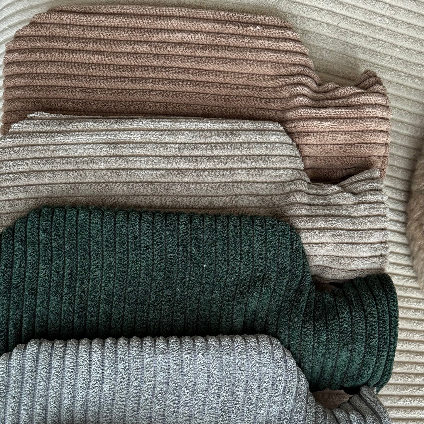 Poufet Wärmflaschen in verschiedenen Farben gestapelt – handgemachte Bezüge aus Breitcord, made in Germany
